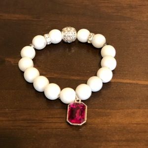 White beaded bracelet w pink sapphire charm